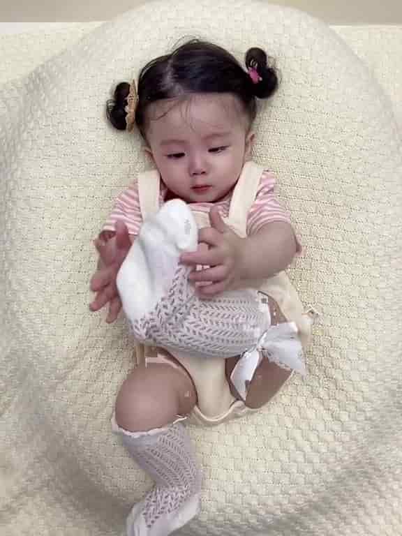 The adorable girl conquered viewers’ hearts when she played with her socks alone.