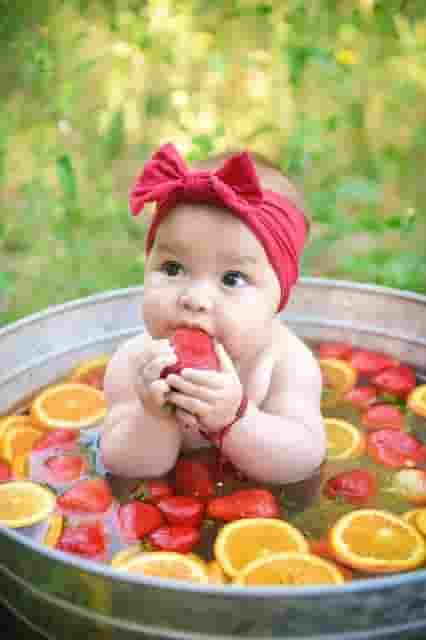 The cuteness of the children is captured through images of them bathing with delicious fruit.